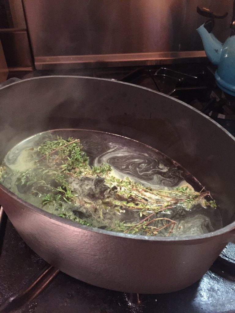 pot with wine and broth and herbs